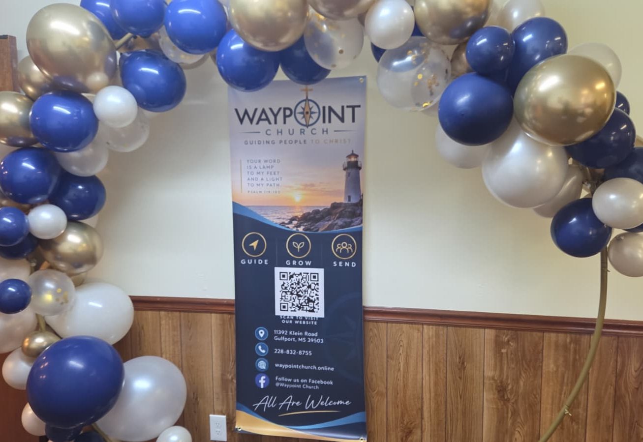 Waypoint Church banner beneath a navy and gold balloon arch